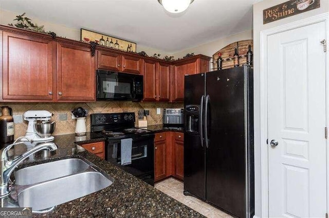 kitchen with tasteful backsplash, dark stone counters, sink, black appliances, and light tile patterned floors