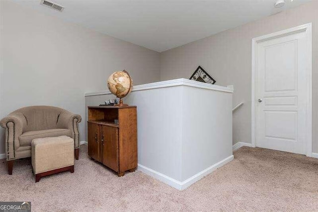 sitting room featuring light carpet