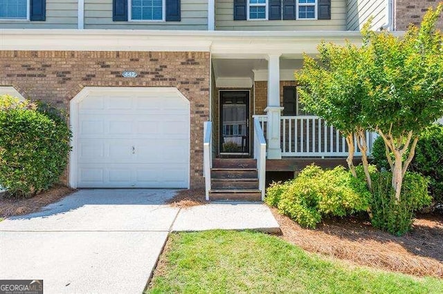 entrance to property featuring covered porch and a garage