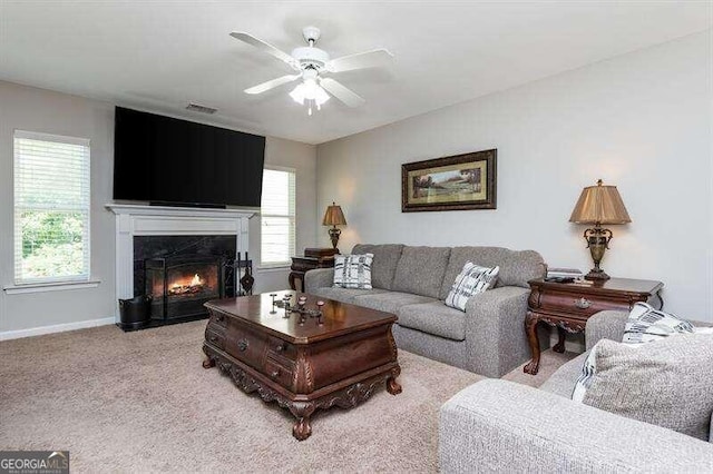 carpeted living room featuring a fireplace, ceiling fan, and a healthy amount of sunlight