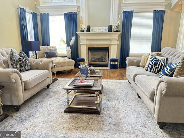 living room with a tile fireplace and hardwood / wood-style floors