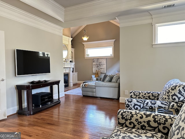 living room featuring dark hardwood / wood-style flooring, a healthy amount of sunlight, and ornamental molding