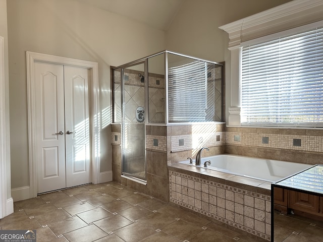 bathroom with shower with separate bathtub and lofted ceiling