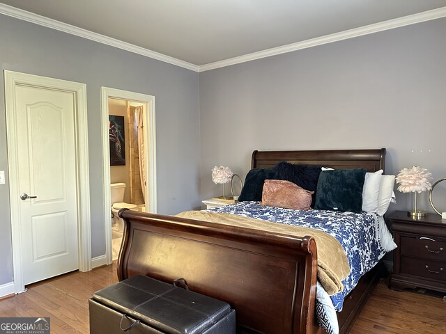 bedroom featuring light hardwood / wood-style floors, ornamental molding, and connected bathroom