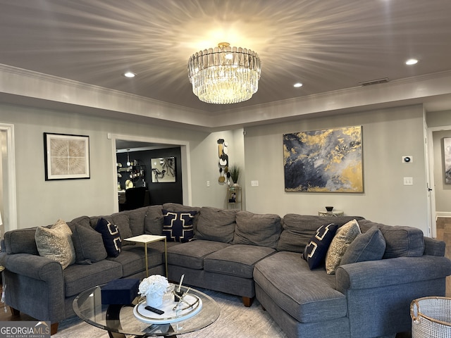 living room with hardwood / wood-style flooring, crown molding, and a chandelier