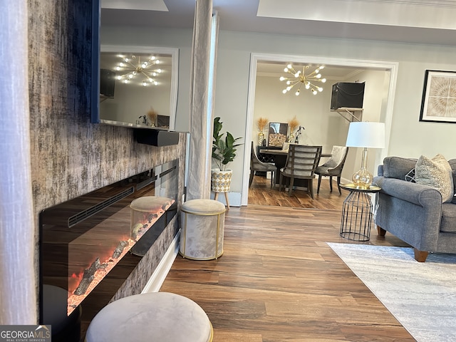 living room featuring crown molding, hardwood / wood-style floors, and a chandelier