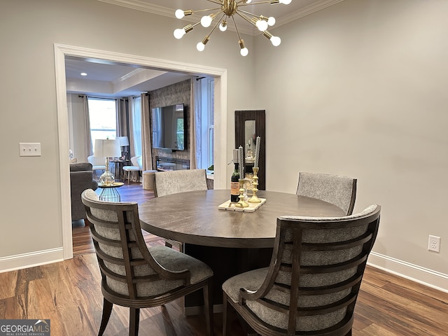 dining area featuring a chandelier, hardwood / wood-style flooring, and ornamental molding