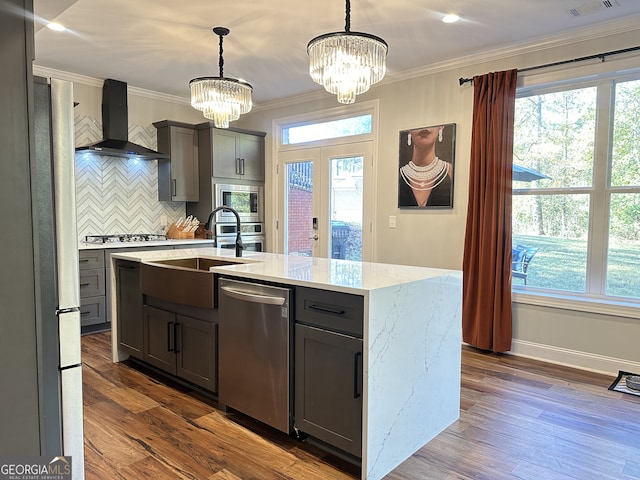 kitchen with wall chimney range hood, dark hardwood / wood-style floors, decorative light fixtures, gray cabinets, and appliances with stainless steel finishes