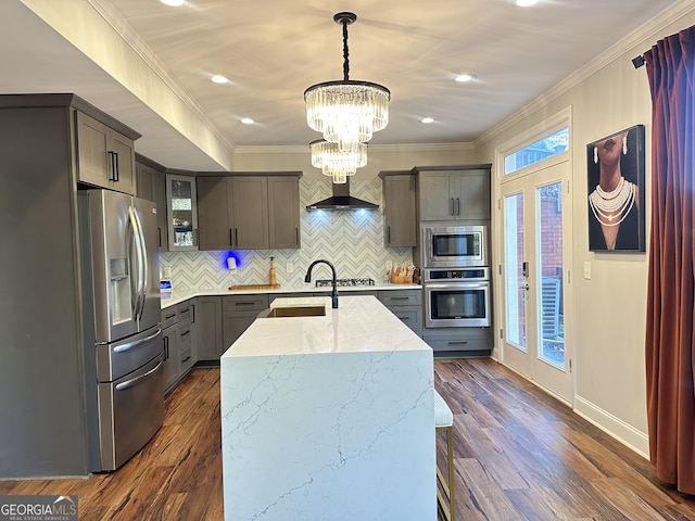 kitchen with light stone countertops, appliances with stainless steel finishes, sink, decorative light fixtures, and dark hardwood / wood-style floors