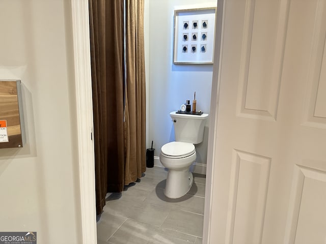 bathroom with toilet and tile patterned floors