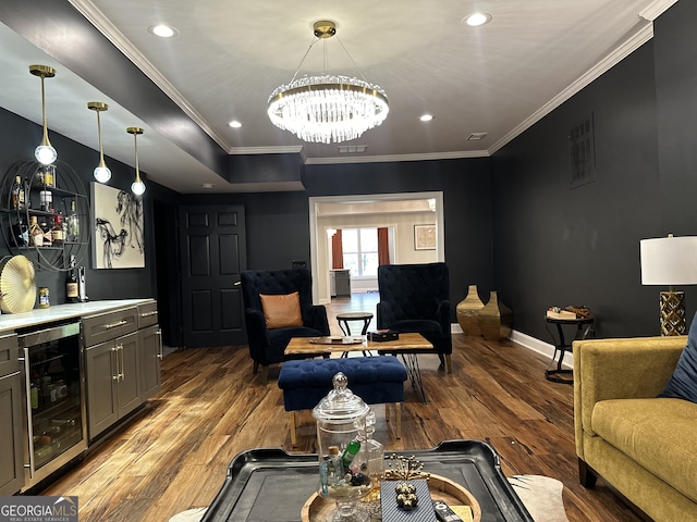 living room featuring hardwood / wood-style flooring, wine cooler, crown molding, and a notable chandelier