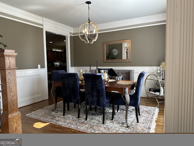 dining space with a chandelier, hardwood / wood-style floors, and crown molding