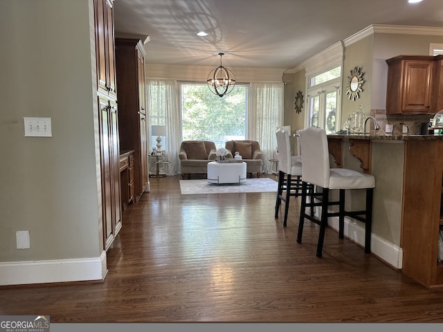 interior space featuring crown molding, sink, dark wood-type flooring, and a notable chandelier