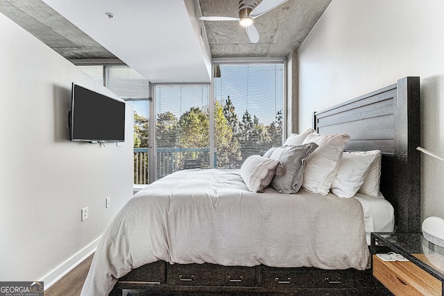 bedroom with multiple windows, hardwood / wood-style floors, expansive windows, and ceiling fan