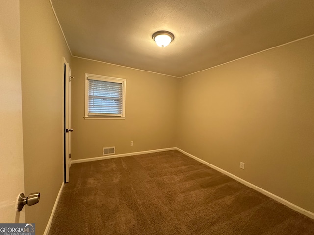 carpeted spare room with a textured ceiling