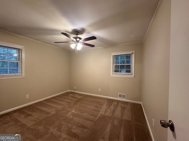 carpeted spare room featuring ceiling fan