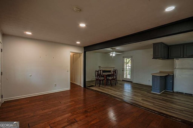 interior space featuring gray cabinetry, ceiling fan, beamed ceiling, white fridge, and dark hardwood / wood-style flooring