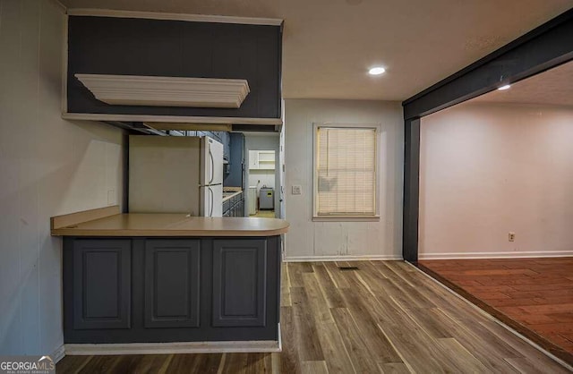 interior space featuring dark hardwood / wood-style floors, white refrigerator, and washer / dryer