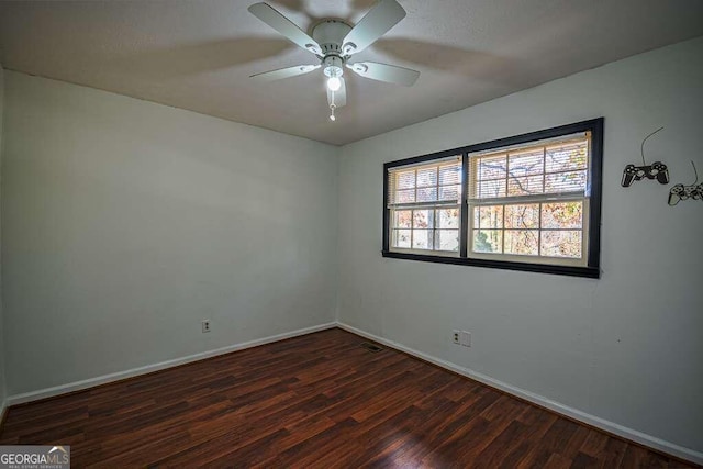 spare room with dark hardwood / wood-style floors and ceiling fan