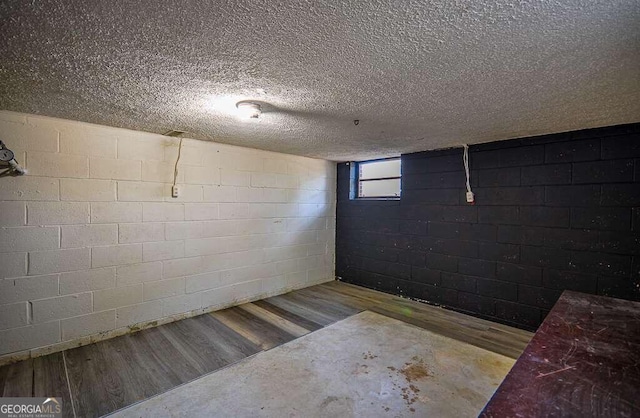 basement with a textured ceiling and light hardwood / wood-style flooring