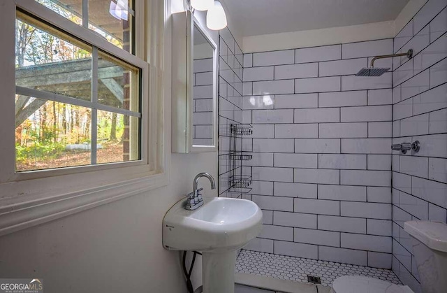 bathroom with toilet and a tile shower