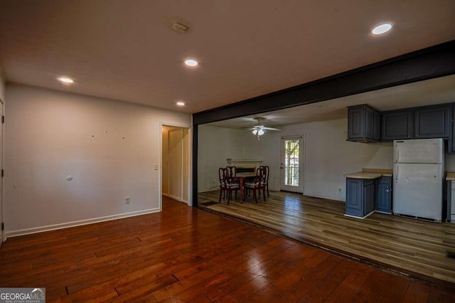 kitchen featuring gray cabinetry, dark wood-type flooring, ceiling fan, beamed ceiling, and white fridge