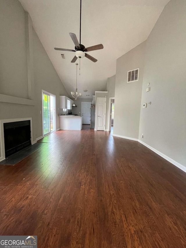 unfurnished living room with ceiling fan, dark wood-type flooring, and high vaulted ceiling