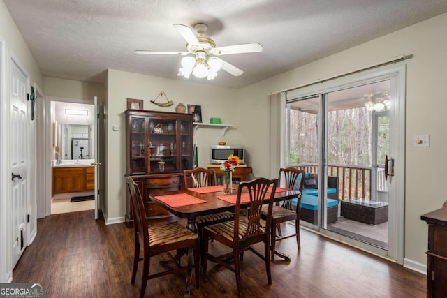 dining room with a textured ceiling, ceiling fan, sink, and dark hardwood / wood-style floors