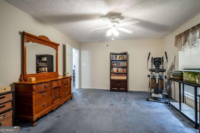 exercise area featuring dark colored carpet, ceiling fan, a textured ceiling, and a wealth of natural light