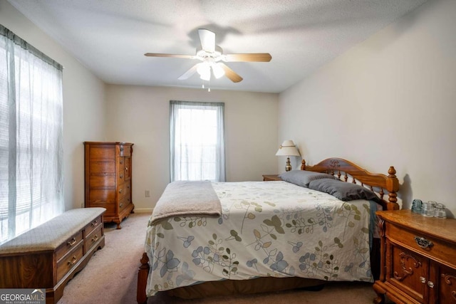 carpeted bedroom with ceiling fan and a textured ceiling