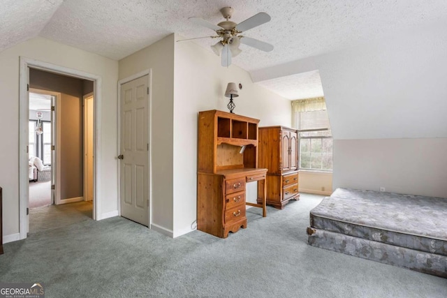 bedroom featuring ceiling fan, lofted ceiling, a textured ceiling, and carpet floors