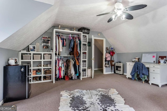 bedroom with ceiling fan, refrigerator, lofted ceiling, a closet, and carpet