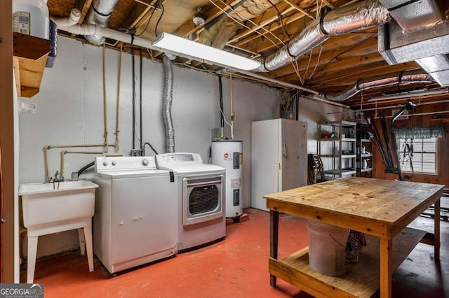 clothes washing area with separate washer and dryer, water heater, and sink