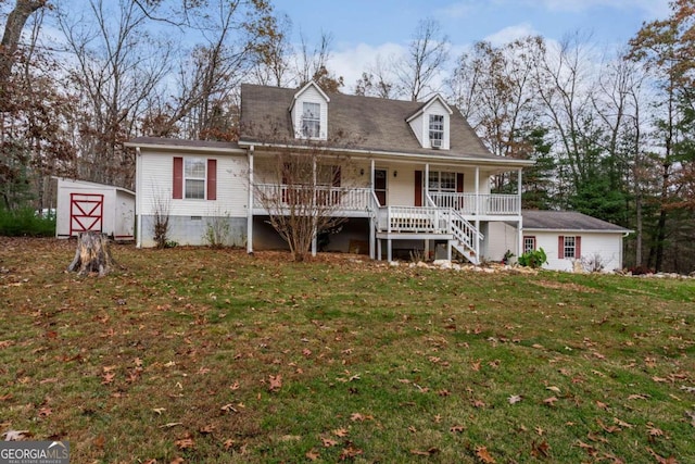 new england style home with covered porch, a front lawn, and a storage unit