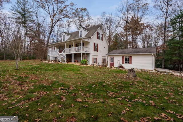 view of front of house featuring an outbuilding, a front lawn, and a porch