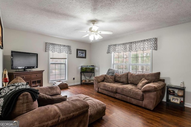 living room with a textured ceiling, dark hardwood / wood-style flooring, and ceiling fan