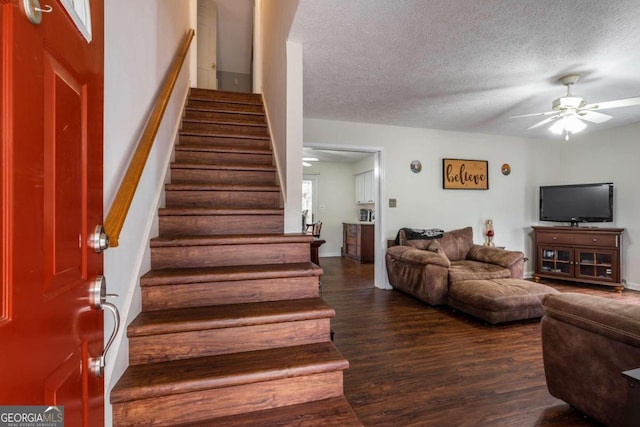 staircase featuring ceiling fan, wood-type flooring, and a textured ceiling