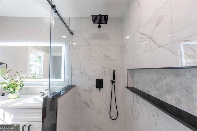 bathroom with a tile shower and sink