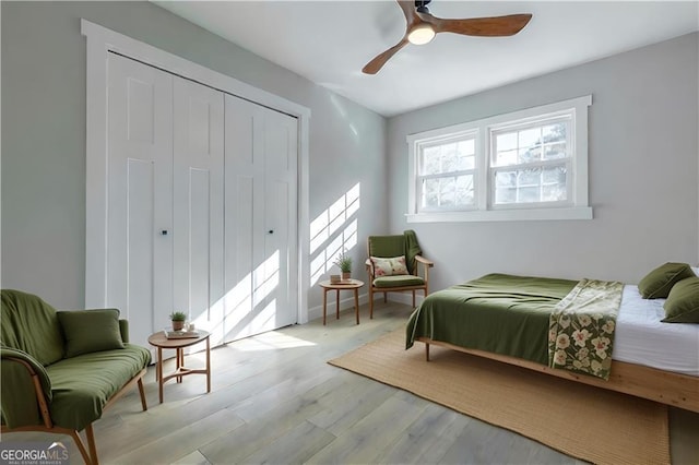 bedroom featuring ceiling fan, a closet, and light hardwood / wood-style flooring