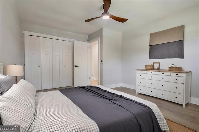 bedroom with a closet, light hardwood / wood-style flooring, and ceiling fan