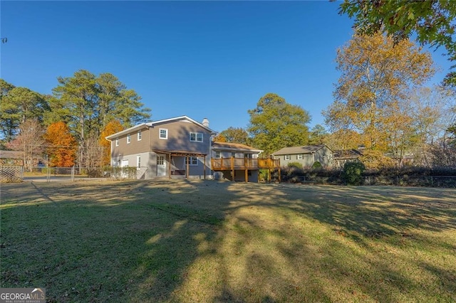 back of property with a deck and a yard