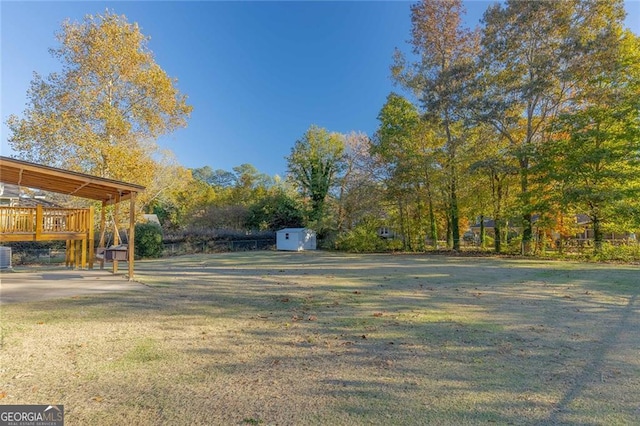 view of yard with a storage unit, cooling unit, and a deck