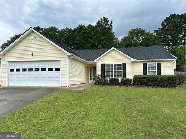 single story home with a front yard and a garage