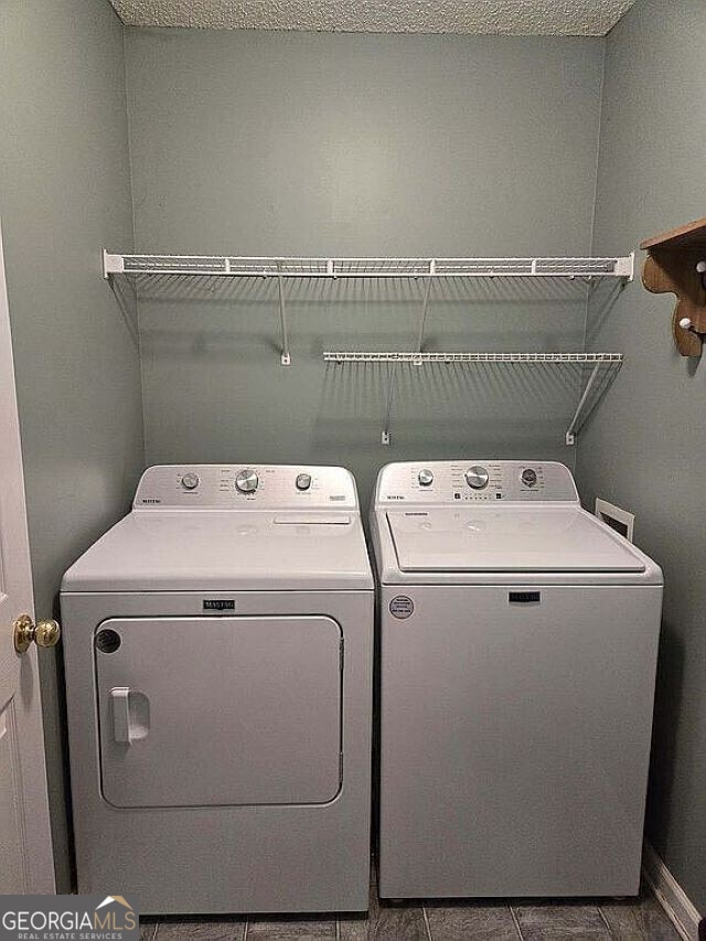 washroom featuring tile patterned floors, independent washer and dryer, and a textured ceiling