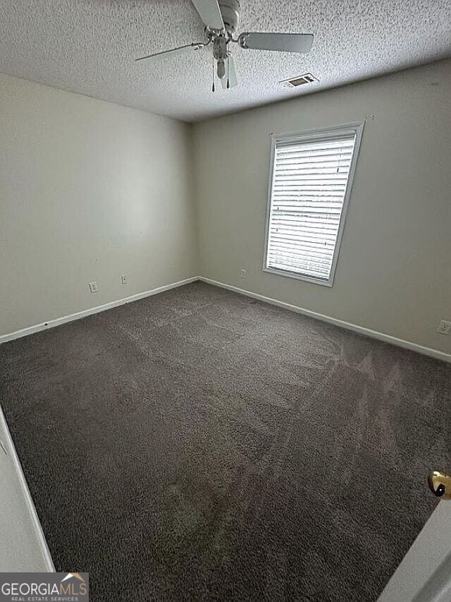 unfurnished room featuring ceiling fan, carpet, and a textured ceiling