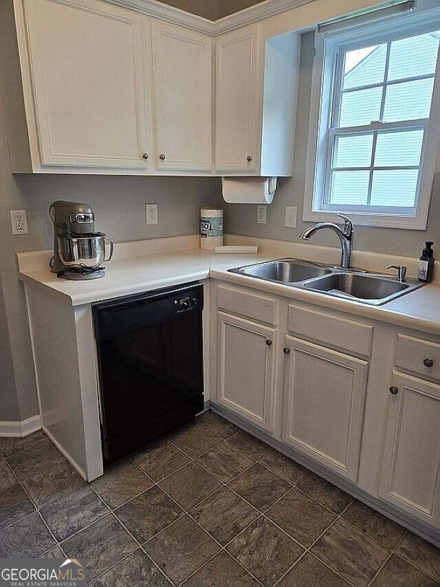 kitchen with dishwasher, white cabinetry, and sink