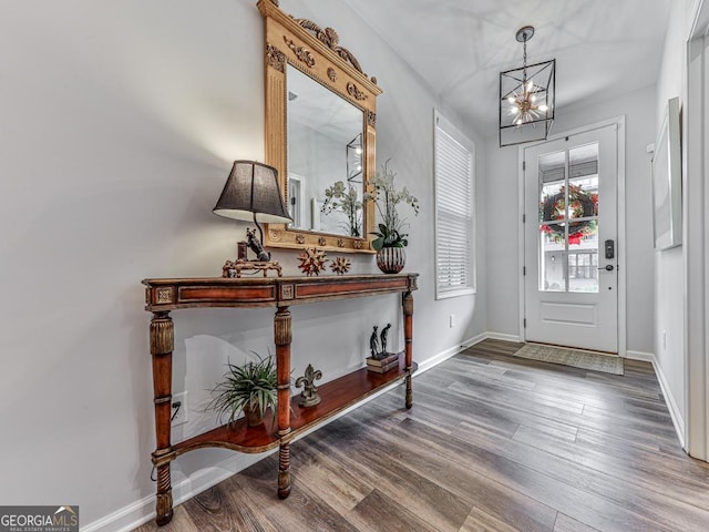 entrance foyer with hardwood / wood-style floors and a notable chandelier