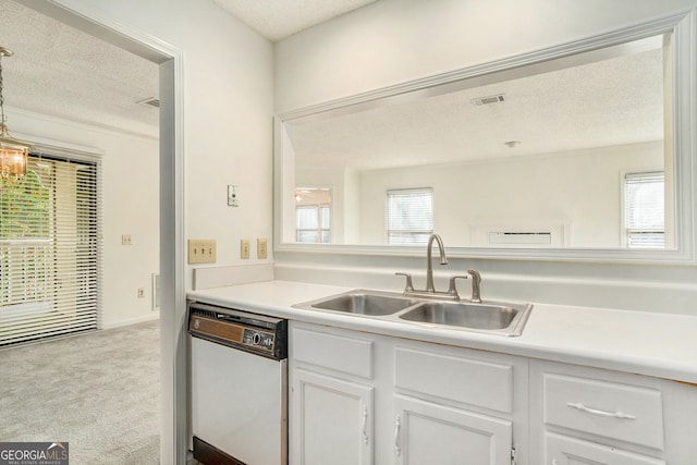 kitchen with sink, white dishwasher, a textured ceiling, light carpet, and white cabinets