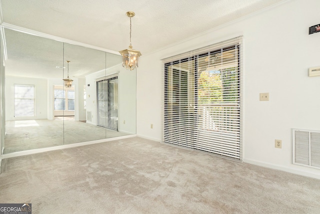 empty room with light colored carpet and a textured ceiling