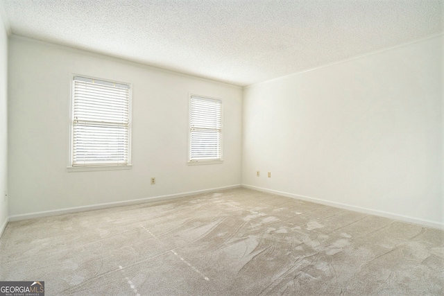 carpeted empty room with a textured ceiling